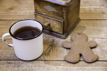 Manual vintage coffee grinder, cup of coffee and ginger biscuits