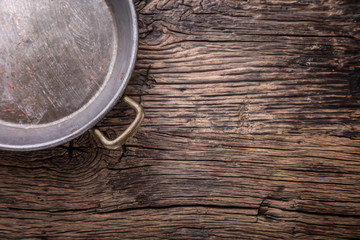 Metal old retro empty pan on oak  kitchen table. Top view.