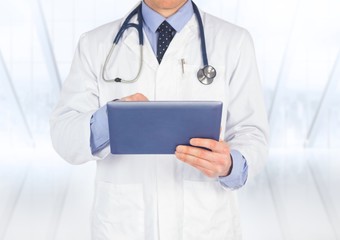 Doctor mid section with tablet against blurry window