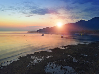 Stony seacoast and mountains on a sunset. Indonesia. Bali.