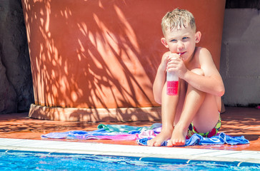 A child at the pool drinking juice