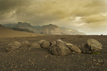 Lunar like landscape with heavy clouds and weird stones on the volcanic sand  - 142393190