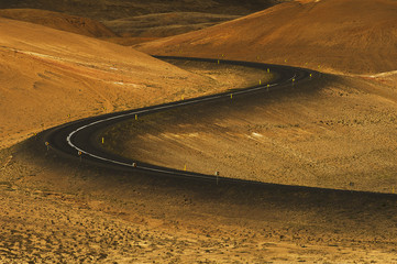 Curved highway road in Iceland between orange mountains 