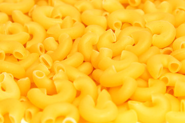 A lot of pasta. Dry pasta. Scattered pasta. Pasta background. Pasta in form of shells. Macaroni products. Macaroni background. Food background.
