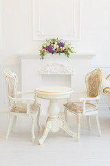 Fototapeta na wymiar Bright luxury white interior living room with flowers . the walls are decorated with baroque ornaments