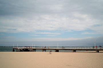 seaside landscape. Beach and pier, cloudy day