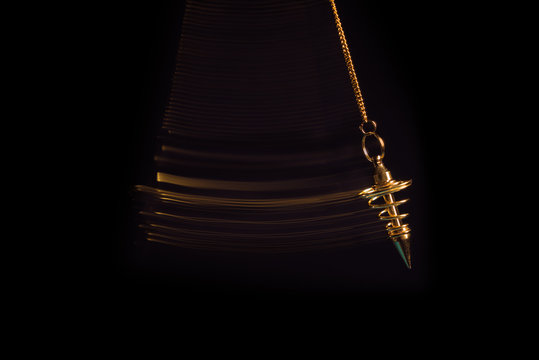 Pendulum used for readings and hypnotism swinging with motion blur