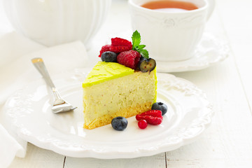 Home pistachio cheesecake with raspberries and blueberries.