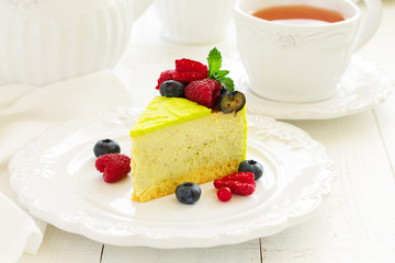 Home pistachio cheesecake with raspberries and blueberries.