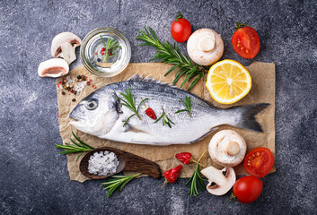 Uncooked dorado fish with rosemary and vegetables