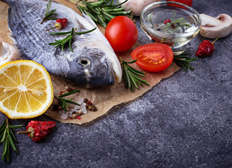 Uncooked dorado fish with rosemary and vegetables