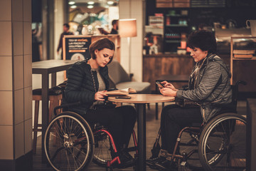 Fototapeta premium Two physically challenged women in a cafe
