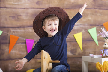 Happy Easter! Sweet little boyplaying a t home with wooden horse.