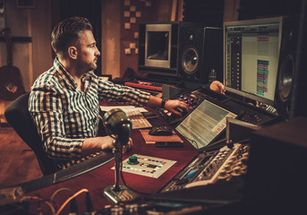 Sound engineer working in boutique recording studio.