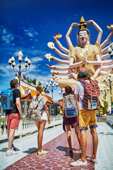 Fototapeta premium group of tourists looking at buddhist temple in thailand