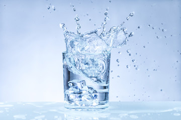 ice cube falling into a glass of water