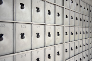 a bank of numbered aluminum mailboxes with combination locks