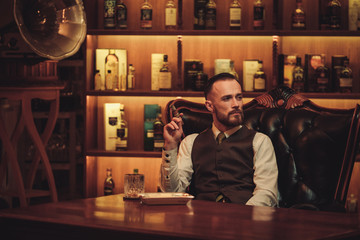 Confident upper class man smoking cigar in gentlemen's club