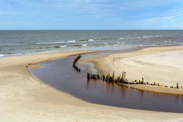 Beautiful sandy beach in Karwia village and wooden breakwater next to the mouth of Karwianka river. Poland.
