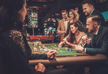 Upper class friends gambling in a casino - 142401932