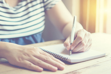  female hands with pen writing on notebook on wooden table , young girl writing into her diary, in the park,Woman writing recipient address on mailing envelope, female hands   sending letter
