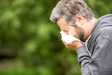 Mann mit Allergie beim Niesen