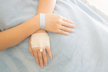 Patient ID Bracelet ,hospital wrist tag,injection in hand,selective focus,vintage color,copy space.