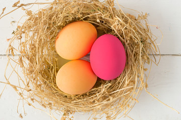 Happy Easter Card - space for text. Easter eggs in nest on rustic wooden background, selective focus image 