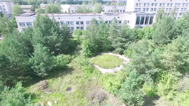 Aerial view over the small town. Aerial survey of buildings and trees. Flying over the yard and over people's heads. Flying over Civil Records Office. Aerial survay of the center of the city.Aerial