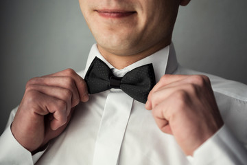 man butterfly clothes,businessman putting on  bow tie. Suit, Hands, care, tie, to correct, to adjust, fashion, bow.