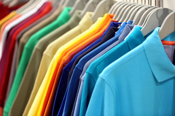 Row of men's polo shirts in wardrobe or store - 142408397
