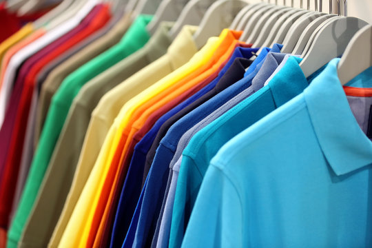 Row of men's polo shirts in wardrobe or store