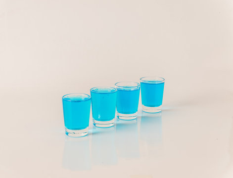 Four Glasses Of Blue Kamikaze, Glamorous Drink, Mixed Drink Poured Into Shot Glasses