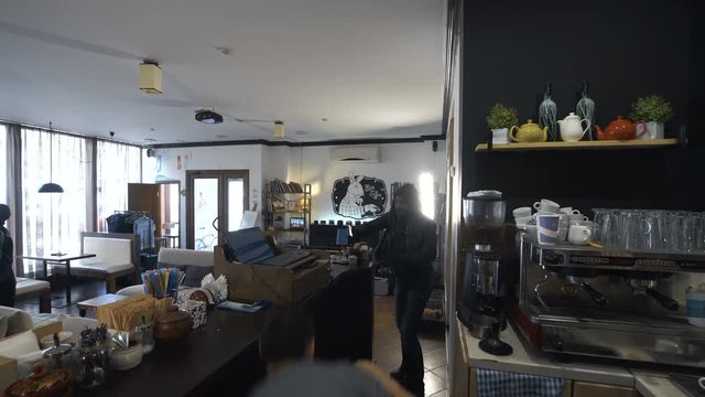 Man in the cafe banishing the gangsters with the baseball bat. Horizontal indoors shot.