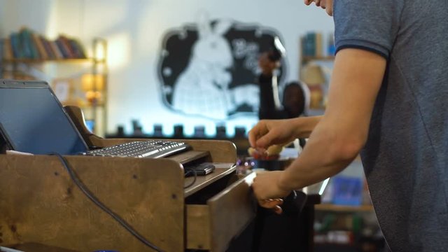 Horizontal croped shot of the shop assistant packing the money for the burglars.