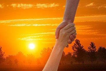 Plakat helping hand with the sky sunset background