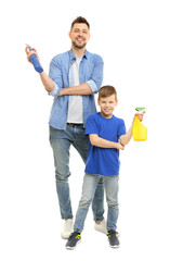 Dad and son with bottles of detergent on white background