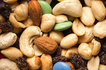 Close up of pile of trail mix with nuts, raisins, and candy