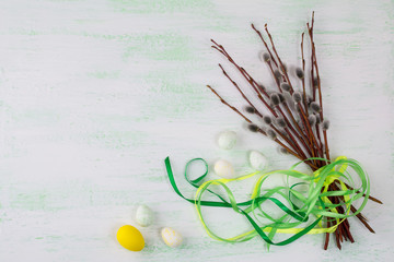 Easter eggs and willow tree branch with green ribbon