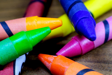 Colorful crayons on wooden table.