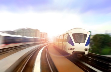 Obraz na płótnie Canvas Modern light rail train on the move with bright sunlight glare