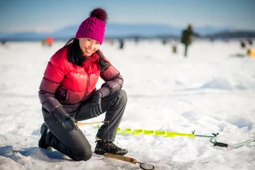 Selbstklebende Fototapeten Woman ice-fishing in the winter © agnormark