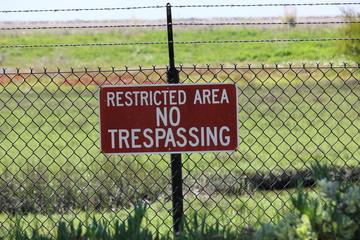 Restricted Area sign on metal fence
