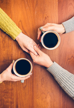 People Drinking Coffee From The Cups And Holding Hands On Romantic Date. Couple In Love On Date.