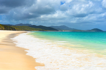 Beautiful tropical beach with white foam sea wave