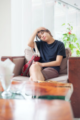 Obraz na płótnie Canvas Teen girl sitting in hotel lobby with neckache or heachache