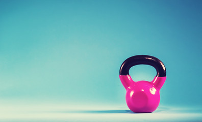 Pink kettlebell on a blue background