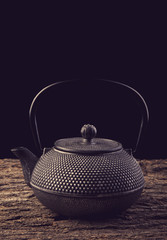 Teapot on a wooden table toning photo