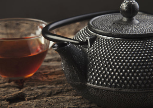 Teapot and cup on a wooden table close up photo