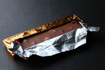 Chocolate bar in aluminum foil packaging represent the food and confectionery concept related idea.